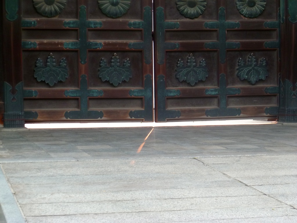 Lumière qui filtre sous la porte d'un temple fermé