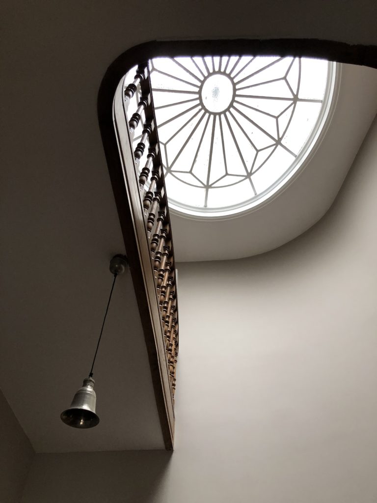 Vue sous un escalier en spirale avec verrière au plafond