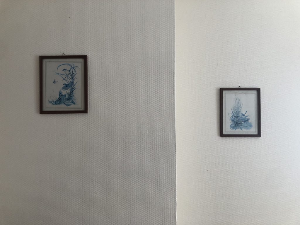 Deux gravures bleutées, sur un mur avec un décrochement, qui créé deux surfaces plus ou moins éclairées