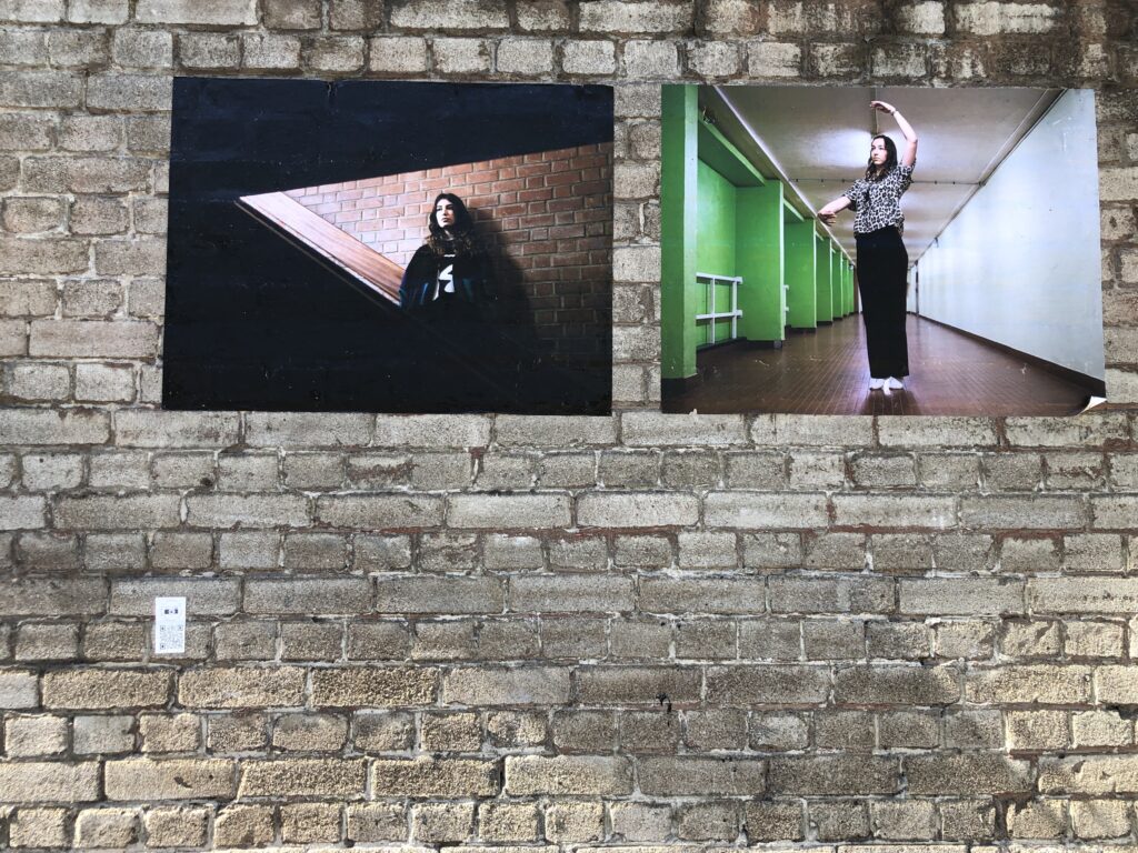 Deux photos d'ado collées à même les briques pour une expo en plein air