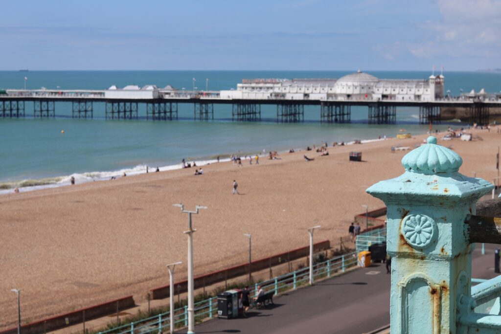 Plage de Brighton avec au premier plan un bout de rambarde turquoise rouillée