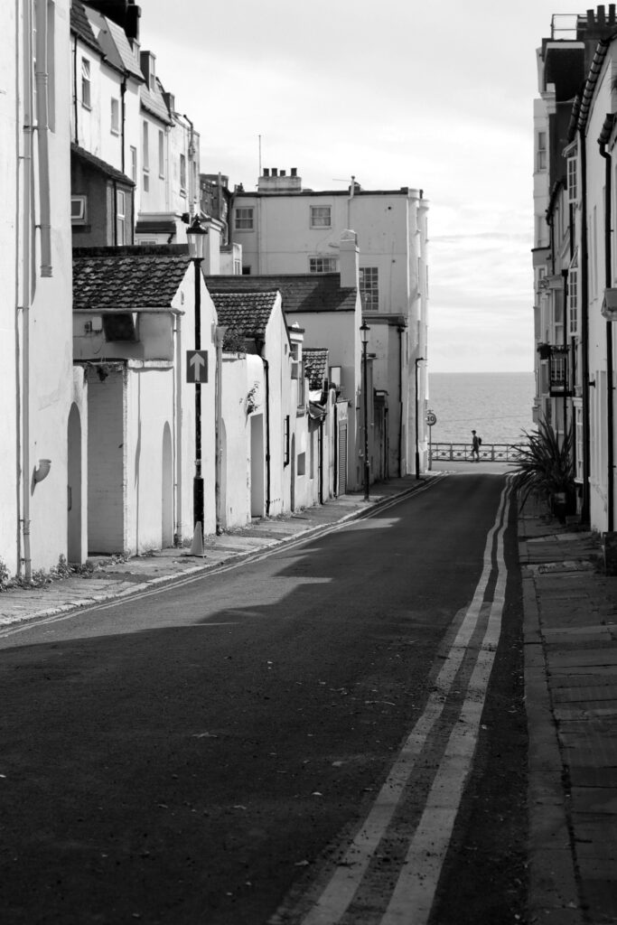 Une rue à double ligne jaune qui mènent vers la mer