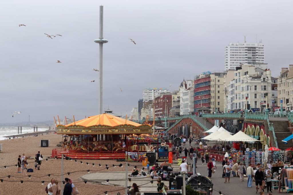 Un bout de plage, un gros manège jaune-orange sous un ciel gris tempête et l'enfilade des immeubles dépareillés sans charme qui forment le bord de mer