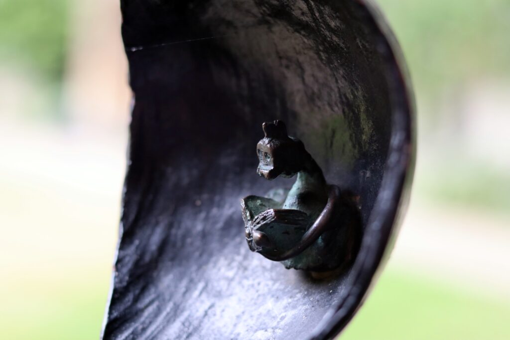 Détail d'un dragon qui lit un livre, miniature dans la feuille en fer d'une balustrade en fer forgé