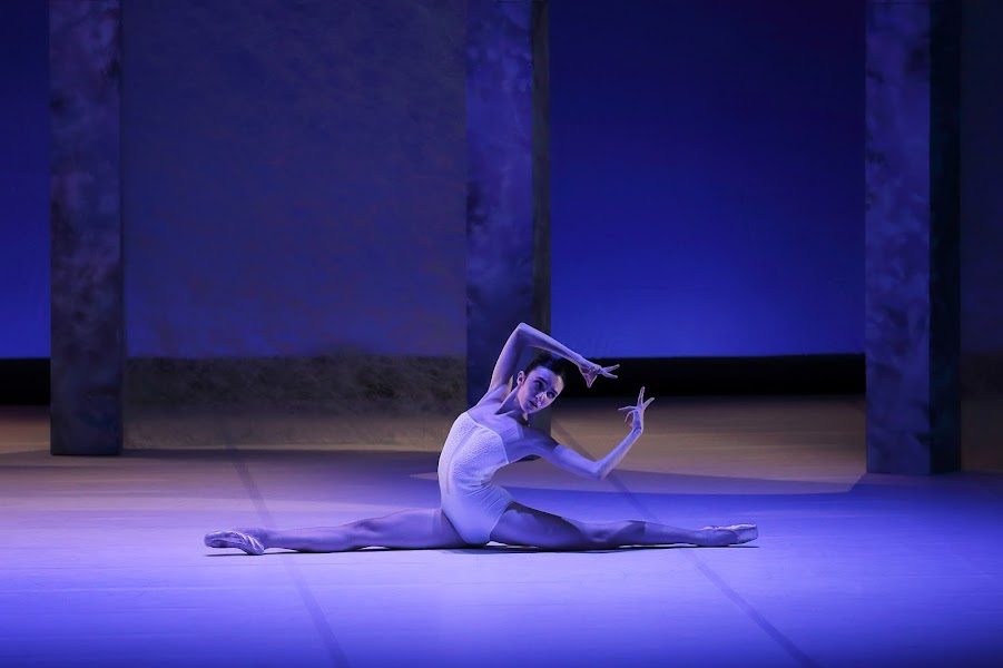 Danseuse en grand écart, bras derrière elle, avec de la tension dans les doigts