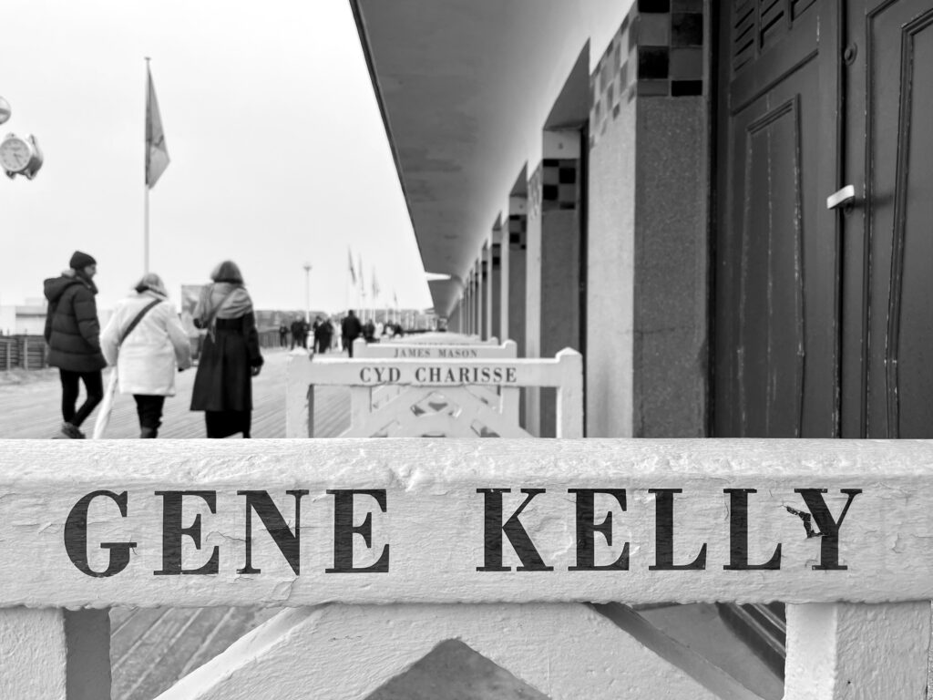 Photo de la promenade de Deauville et de ses barrière avec "Gene Kelly" au premier plan et "Cyd Charisse" derrière