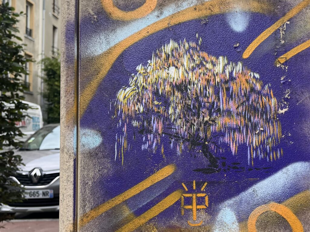 Sur un comptoir électrique de la ville, dessin (au pochoir je dirais) d'un saule pleureur aux lianes blanches, jaunes, roses, mauves.