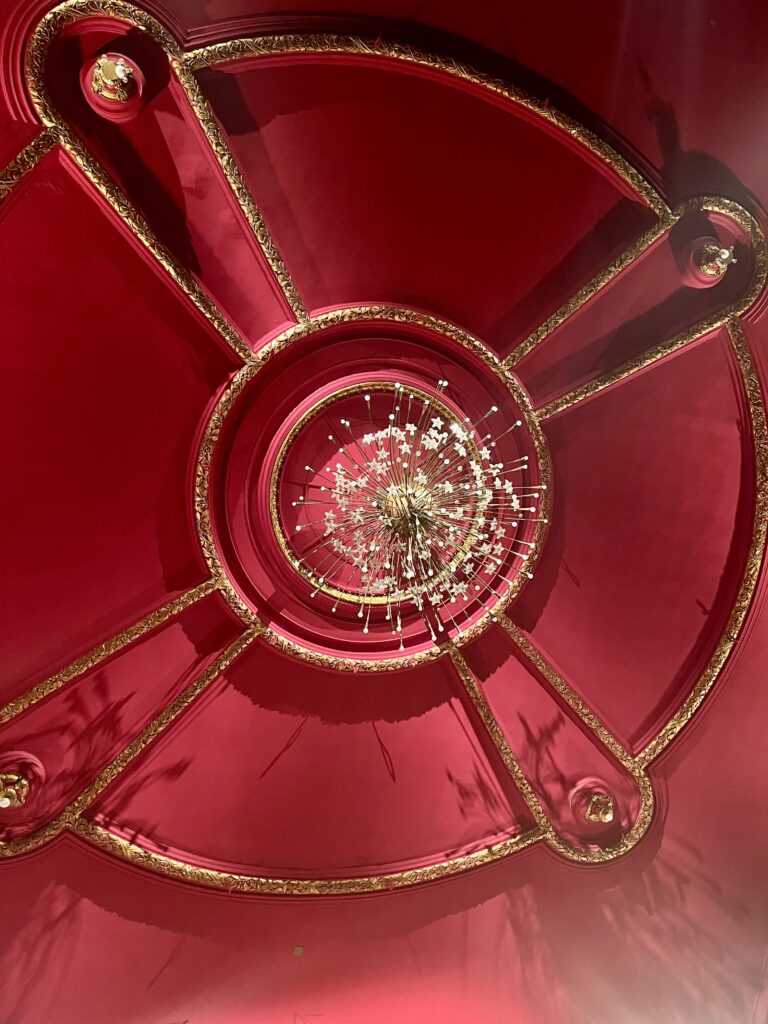 Lustre et décor du plafond tout rouge d'un théâtre à l'italienne