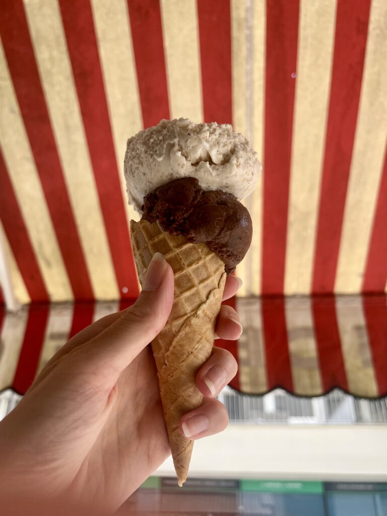 Glace posant devant la devanture rayée de l'épicerie